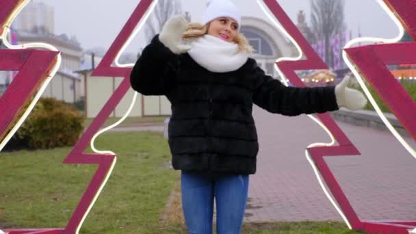 Funny woman in warm white hat, scarf, mittens dancing, laughing outdoors — Stock Video