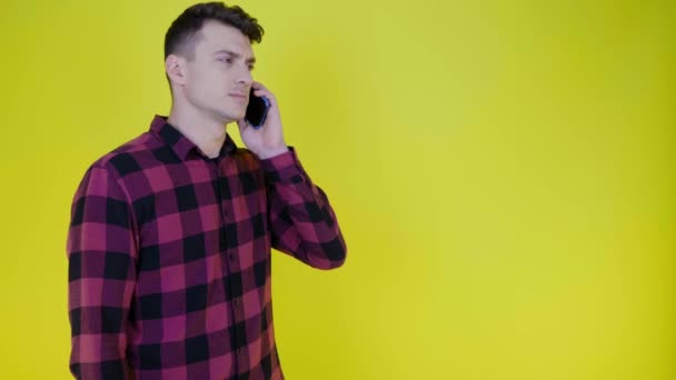 Man Een Roze Geruite Shirt Accepteert Oproep Houdt Smartphone Aan — Stockvideo