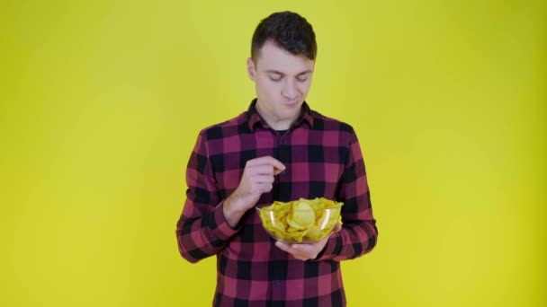 Man Een Roze Geruite Shirt Eet Chips Met Glazen Schaal — Stockvideo