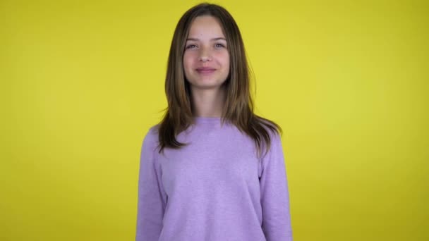 Menina Adolescente Rosa Suéter Sorrisos Olha Câmera Fundo Amarelo Com — Vídeo de Stock