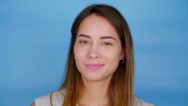 Cerca de la cabeza hermosa mujer positiva en camiseta gris guiña un ojo y sonríe — Vídeo de stock