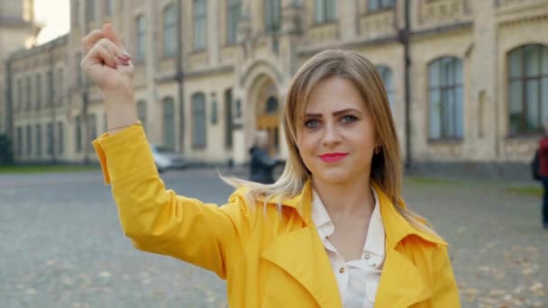 Pozitivní žena v bílé halence, žlutý plášť luskne prsty a usměje se — Stock video
