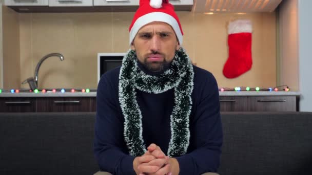 Homem irritado em Ano Novo chapéu vermelho Papai Noel assiste televisão, indignado — Vídeo de Stock