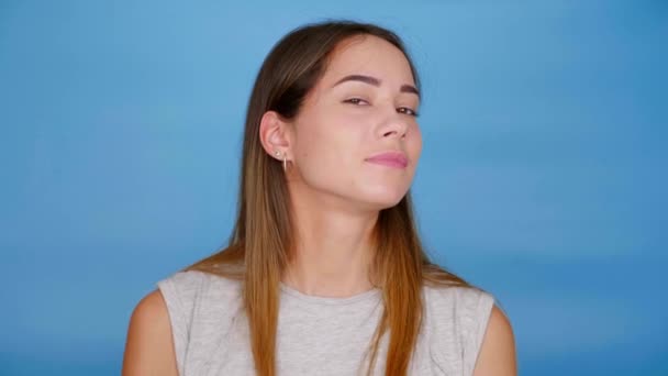 Mujer positiva en camiseta gris posa cámara, endereza el cabello en la cabeza, sonríe — Vídeos de Stock