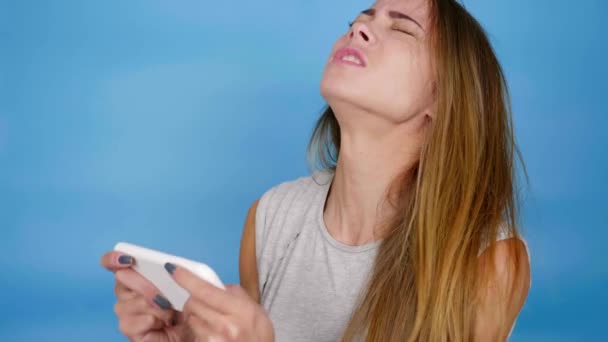 Emotionele vrouw gamer speelt video game op smartphone, wordt boos, verliest — Stockvideo