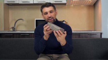 Neşeli yakışıklı adam kutuları kar taneleriyle, kucaklaşmalarla, hediyelerle, gülümsemelerle inceliyor.