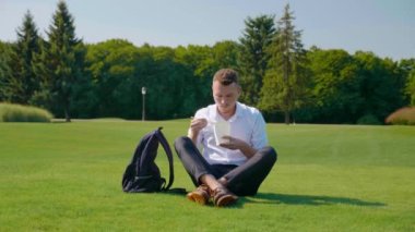 Adam vejetaryen yemeğini ekolojik bir paketle yiyor, kaşlarını çatıyor ve hoşlanmadığını gösteriyor.