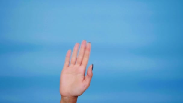 Привет или до свидания. Женщина машет рукой, показывает большие пальцы вверх, как на синем фоне — стоковое видео