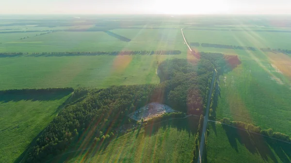 Flygfoto soptipp grön skog, fält, väg på sommaren solnedgång, solljus — Stockfoto