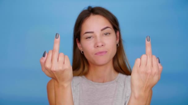 Mujer Seria Camiseta Gris Muestra Dedo Medio Sobre Fondo Azul — Vídeo de stock