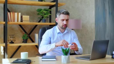Merkez ofisteki iş adamı kablosuz kulaklığı takar ve dizüstü bilgisayarda çalışmaya başlar. Gri saçlı sakallı adam şirket çalışanlarıyla çevrimiçi görüntülü sohbet konferansına bağlanıyor. Yavaş çekim