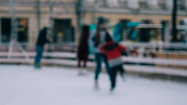 Defocus. Meisje trainer leert kleine jongen schaatsen op ijs in de winter — Stockfoto