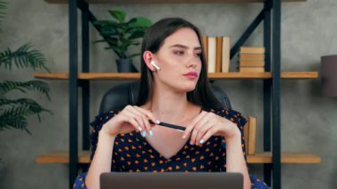 Düşünceli bir iş kadını, ofisteki kablosuz kulaklık takıyor. Çözüm sorununu düşünüyor. Güzel bayan öğretmen, öğrencilerin internetten eğitim videolarına uzaklık katıp dizüstü bilgisayarı arıyor.