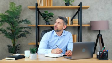 Erkek öğrenci pratik iş yapar. Çözüm probleminin defterde yazdığını düşünür.