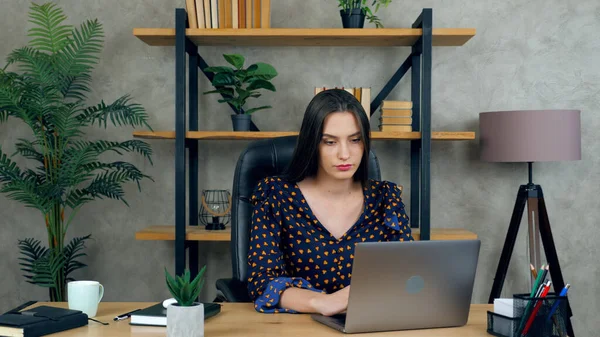 Güzel esmer kadın internette çalışıyor. Laptop bilgisayar kullanıyor.