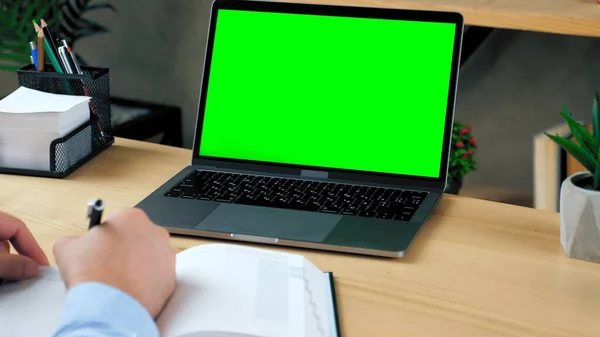 Green screen laptop computer. Man student study writes information in notebook