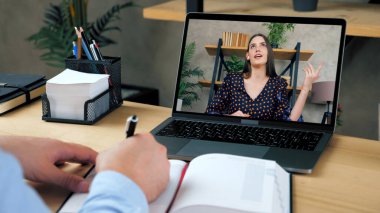Laptop ekranındaki kadın öğretmen uzak web kamerası ve uzaktan eğitim ile öğretiyor.
