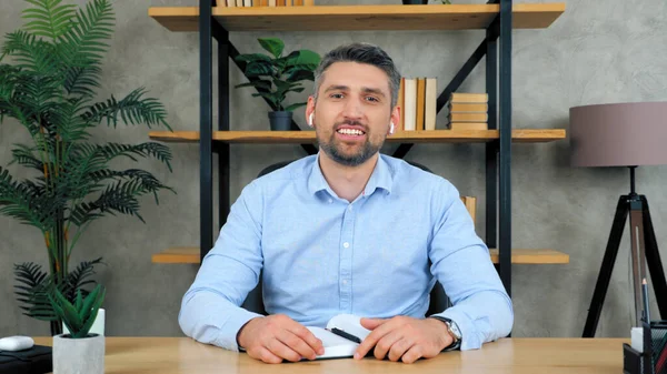 Man looks into camera listening to interlocutor on video call chat conference