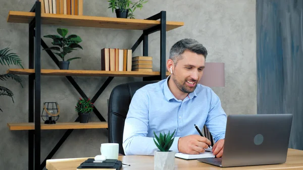 Adam öğrencilere çevrimiçi video konferansı öğretiyor sohbet web kamerası laptopunu arıyor