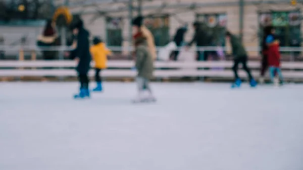 Defocus Männer Frauen Kinder Schlittschuh laufen auf Eis im Winter. Menschen, die Amateursport betreiben — Stockfoto