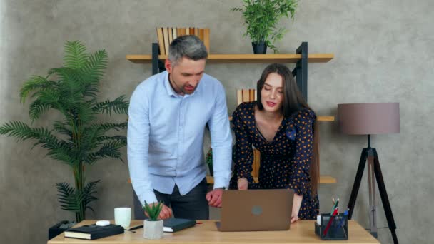 笑顔の女性と男は 問題を解決するための助けを満たすためのプレゼンテーションを準備するオフィスで一緒に肘の従業員を迎える ラップトップコンピュータ上のビジネスマンへの進捗報告を示す女性マネージャー — ストック動画