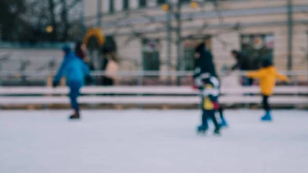 Defocus. Männer Frauen Kinder Schlittschuh laufen auf dem Eis im Winter. Menschen, die Amateursport betreiben — Stockfoto