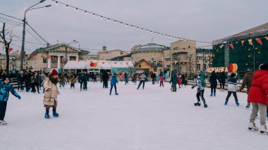 Erkek kadın, çocuk, büyükanne ve büyükbaba kışın buz üstünde kayıyor.
