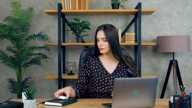 Laptop kullanan bir kadın çevrimiçi görüntülü sohbet konferansına bağlanıyor