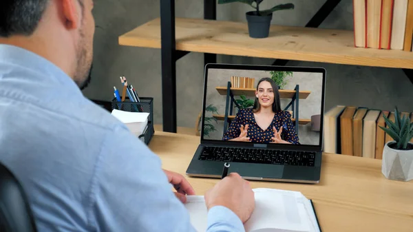 Studente uomo che studia online da computer portatile videochiamata conferenza, scrive nel taccuino — Foto Stock