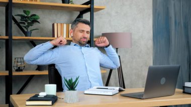Yorgun adam ısınıyor vücut esnetiliyor sıkı çalışan dizüstü bilgisayardan sonra kaslar kasılıyor.
