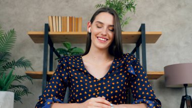 Webcam gülümseyen kadın kapalı gözlü ofis masasında sandalyede oturuyor.