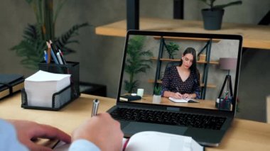 İş adamı ve iş kadını yöneticileri, internet konferansında uzaktan iletişim kurarak sohbet görüntüsü, sohbet bilgisayarı, web kamerası, not defterine, karantina salgınına dair bilgiler yazıyorlar.