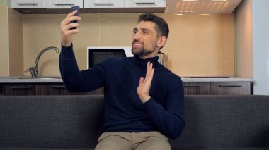 Merhaba ya da güle güle. Adam, kız arkadaşının ailesiyle görüntülü iletişim kuruyor.