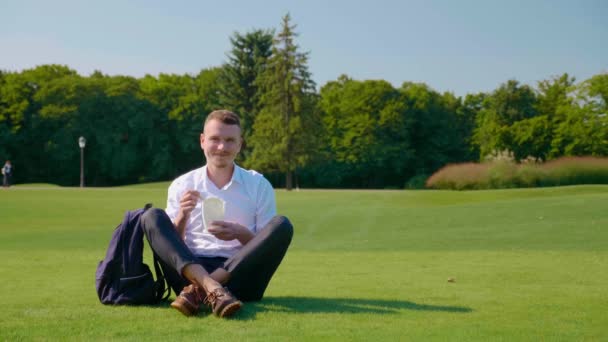 Homme regarde appareil photo et sourit avec le déjeuner végétarien dans un paquet respectueux de l'environnement — Video