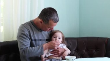 Baba bebek kaşıkla dener. Evde oturan baba rolü