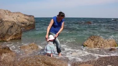 Bebeğin ilk adımları deniz kıyısında. Anne ve kızı sahilde