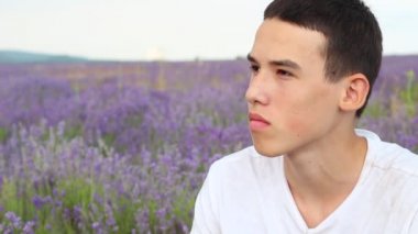 Rüya gibi genç delikanlı. Lavanta bir alanda yalnız yalnız depresyonda çocuk portresi