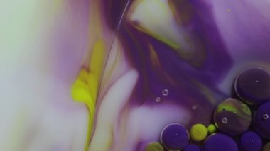 Soyut renkli arkaplan. Sarı ve mor boya. Suyun altında hareket eden renkli mürekkep kabarcıkları.