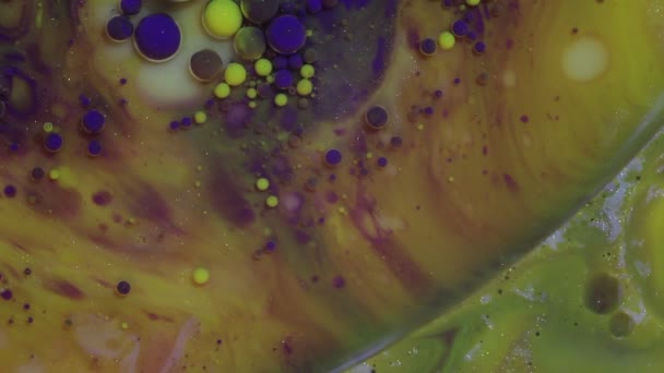 Fond lumineux coloré abstrait. Peinture jaune et violette. Bulles hypnotiques multicolores se déplaçant sous l'eau gros plan. Beaux motifs scintillants qui rappellent les galaxies et les planètes 