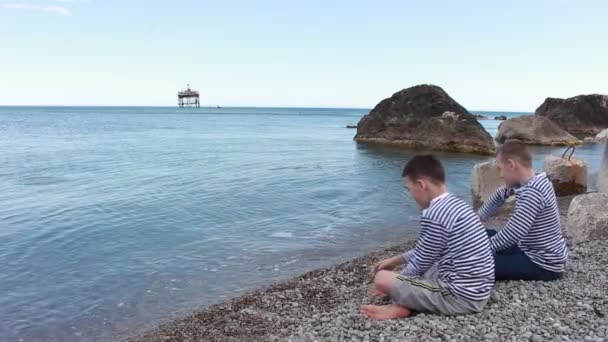 Dois Meninos Sentam Praia Olham Para Mar — Vídeo de Stock