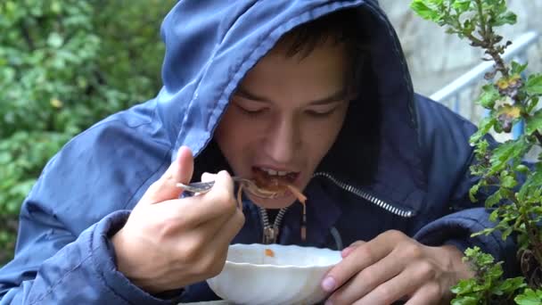 Adolescente Sta Mangiando Fuori Sotto Pioggia — Video Stock