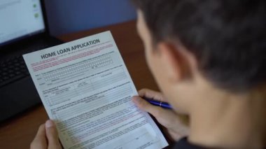 Genç bir adam için bir ev kredisi uyguluyor. Kredi başvuru formu bir kağıt sayfası