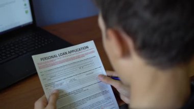 Genç bir adam için kişisel bir kredi ayırıyor. Kredi başvuru formu bir kağıt sayfası