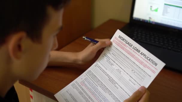 Jovem Está Candidatando Uma Hipoteca Formulário Pedido Crédito Numa Folha — Vídeo de Stock