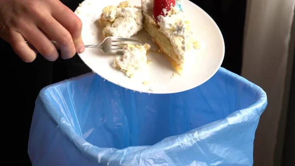 Food Waste Reduction. Throwing away dessert in the trash.  Leftovers from a meal, expired food. Wasted stale food at home
