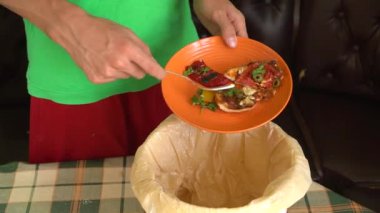Bir adam artık pizzayı çöp kutusuna atar. Gıda atıklarını azaltma. Evsel atıkların ayıklanması, gübreleme, geri dönüşüm, sıfır atık