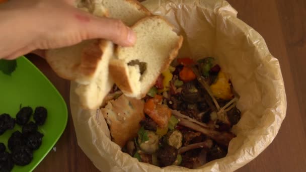 女性は食べられないパンの残骸をゴミ箱に投げ入れる 食品廃棄物を減らす 家庭廃棄物の選別 堆肥化 リサイクル 廃棄物ゼロ — ストック動画
