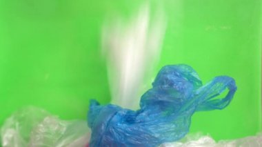 Kullanılan boş eski alışveriş plastik torbalar, şal (film) ve çuvallar bir yığın. Yeşil arka plan (Chroma Key). Ev çöplerini ayıklama ve geri dönüştürme. Plastik kirliliği. Azaltın, Yeniden Kullanın, Geri Dönüştürün. Sıfır atık