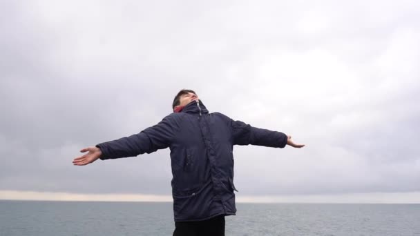 Šťastný Mladý Muž Stojící Vrcholku Skály Moře Zvedá Ruce Užívá — Stock video