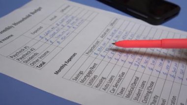 Bir Gelir ve Gider İzleme Belgesi oluşturuluyor. Para kazanma ve harcama. Kağıttaki figürlerin el yazısı ya da anahtarlanması